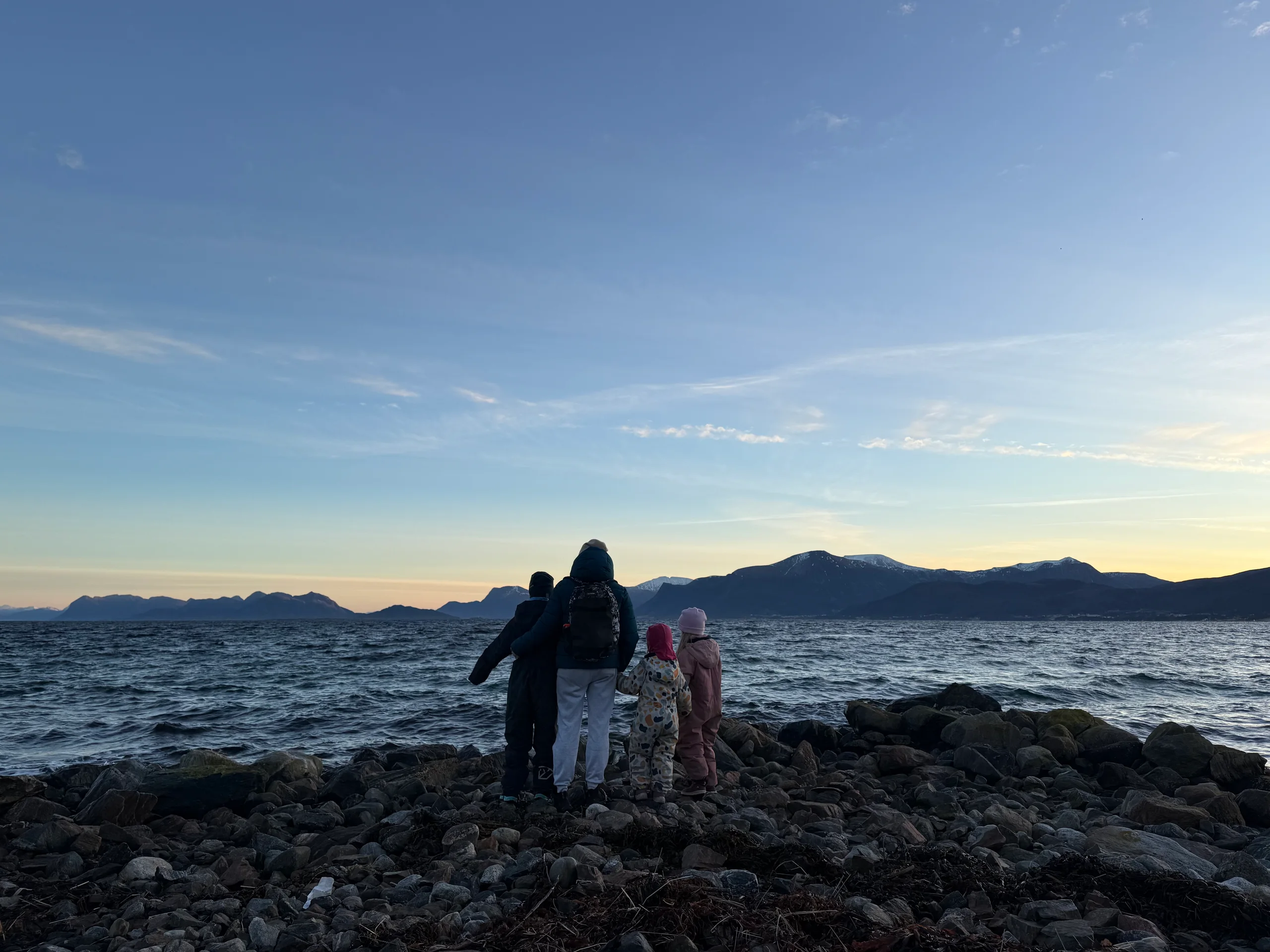 Ein familie ser utover havet frå fjøra
